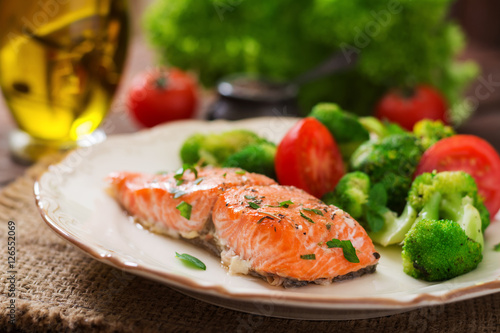 Baked fish salmon garnished with broccoli and tomato. Dietary menu. Fish menu. Seafood - salmon.