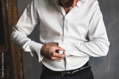 Preparations for the wedding, the groom wears cufflinks