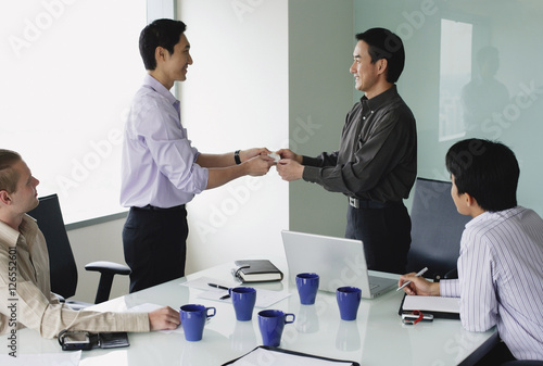 Obraz na płótnie Executives in meeting room, exchanging business cards w salonie