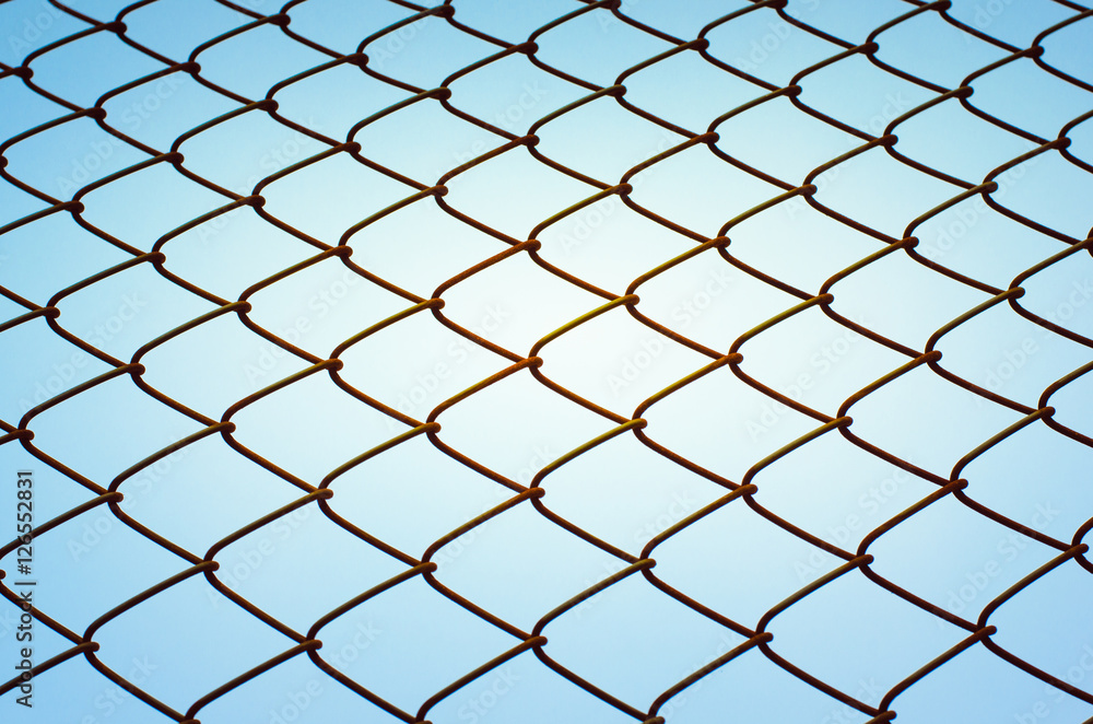 rusty metallic wire mesh fence with blue sky to concept no freedom rusty metallic wire mesh fence with blue sky to concept no freedom