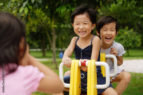 Young girls in playground, playing on seesaw