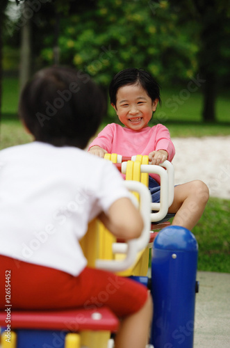 Two girls playing on a seesaw