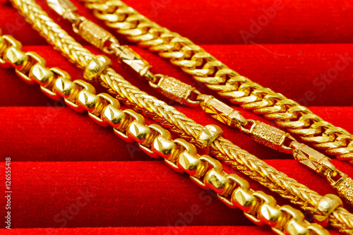 Group of many design gold jewelry on red background