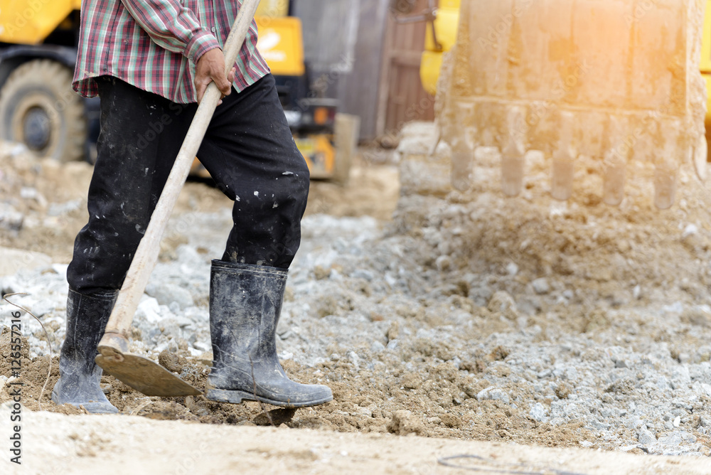 The workers were wearing boots digging with hoe,cra The workers were wearing boots digging with hoe,cra