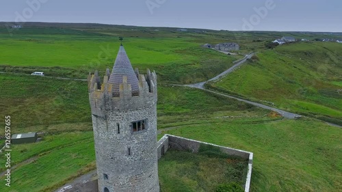 The closer look of the brick walled Ballinalacken Castle found in the green fields in West Ireland photo