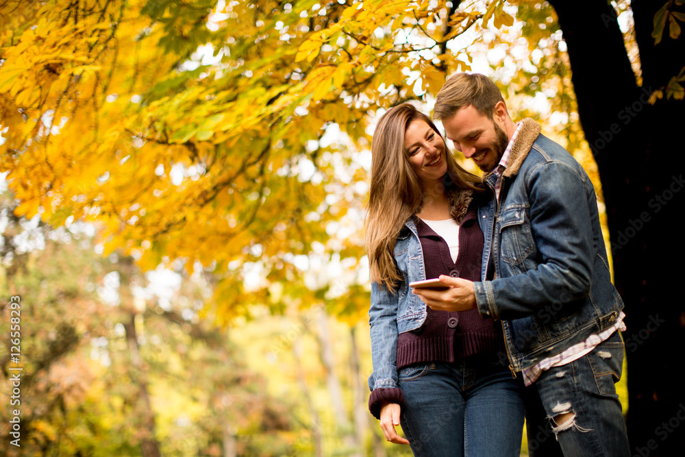 Couple with phone in autumn park Couple with phone in autumn park