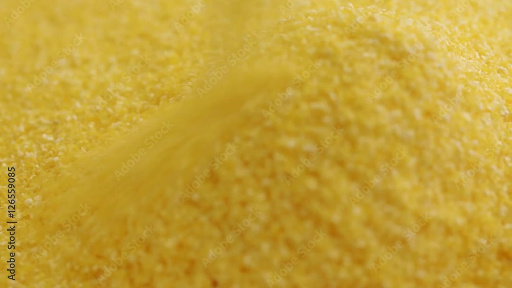 Corn semolina poured into wood bowl; extreme close up; Corn semolina poured into wood bowl; extreme close up;