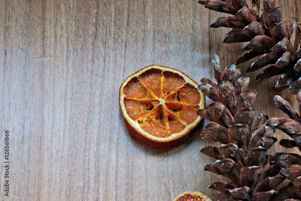 Dried orange slice and pine cones on a wooden table Dried orange slice and pine cones on a wooden table