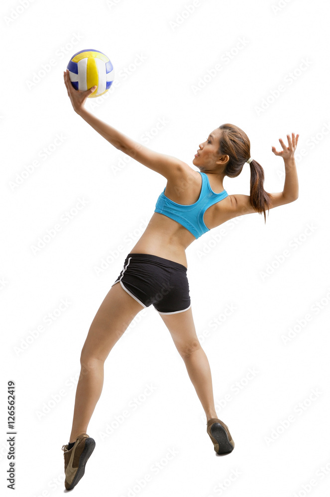 Young woman jumping, preparing to hit volleyball