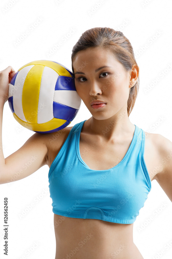 Young woman holding volleyball on shoulder Young woman holding volleyball on shoulder