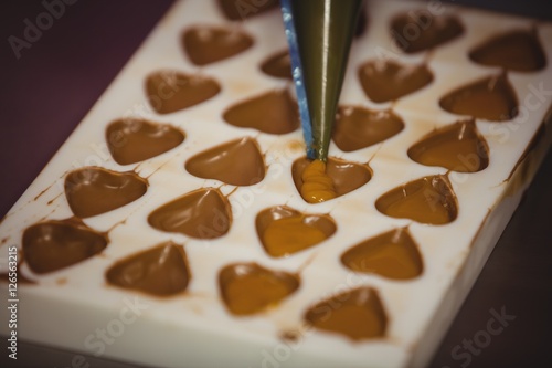 Filling a chocolate mold with a piping bag