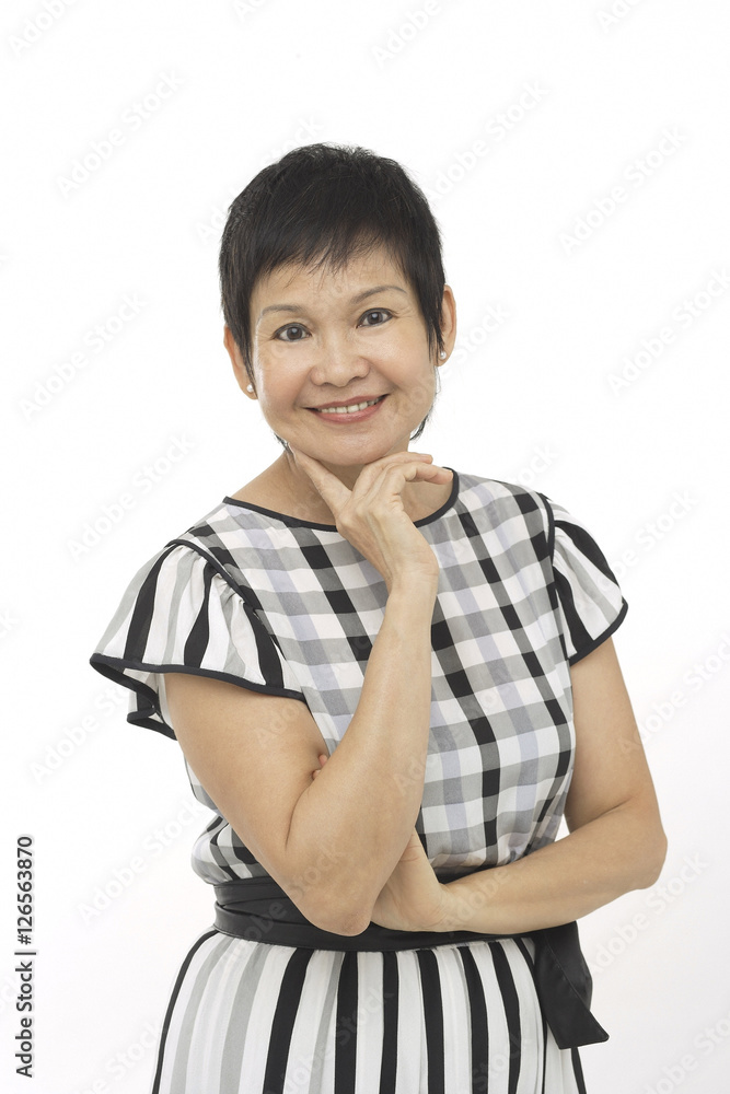 Mature woman against white background, hand on chin, smiling at camera Mature woman against white background, hand on chin, smiling at camera