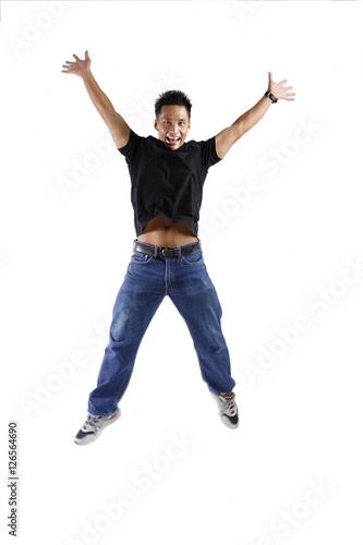 Young man jumping, arms and legs outstretched