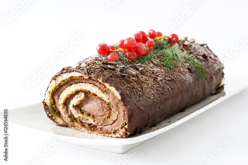Chocolate yule log cake with red currant isolated on white background 