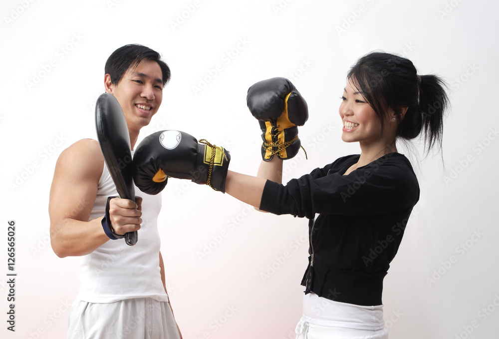 Young woman with boxing gloves, practicing with trainer Young woman with boxing gloves, practicing with trainer