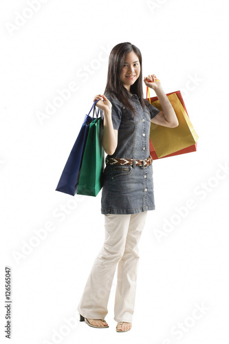 Young woman standing with shopping bags, looking at camera