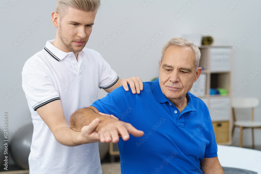 physiotherapeut untersucht die schulter eines älteren patienten physiotherapeut untersucht die schulter eines älteren patienten