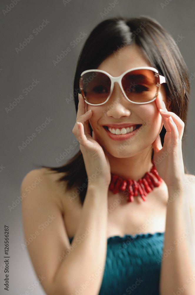 Woman wearing large sunglasses, smiling at camera Woman wearing large sunglasses, smiling at camera