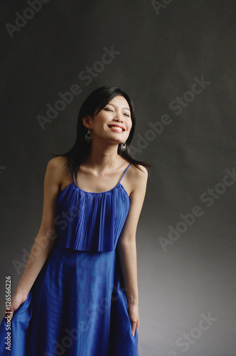 Woman in blue dress, eyes closed, smiling