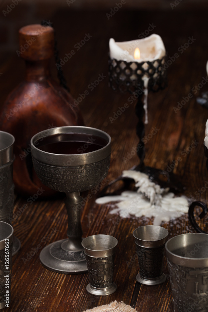 Burnt candle on the table. Against the backdrop of a still life of a medieval Burnt candle on the table. Against the backdrop of a still life of a medieval