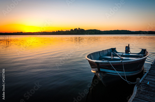 Принти на полотні fishing boat on tranquil lake at sunset in Minnesota