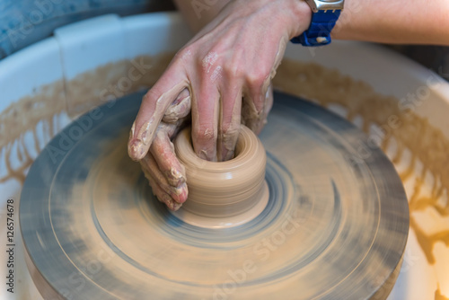 womens hands of a potter creating an earthen jar