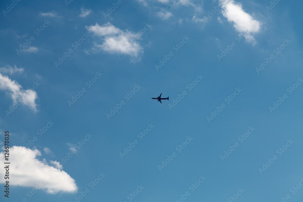 Airplane in the blue sky with clouds