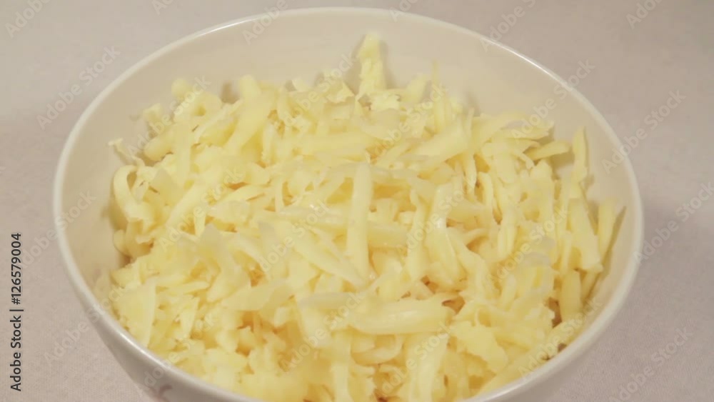 Grated cheese in a bowl. Rotation. Grated cheese in a bowl. Rotation.