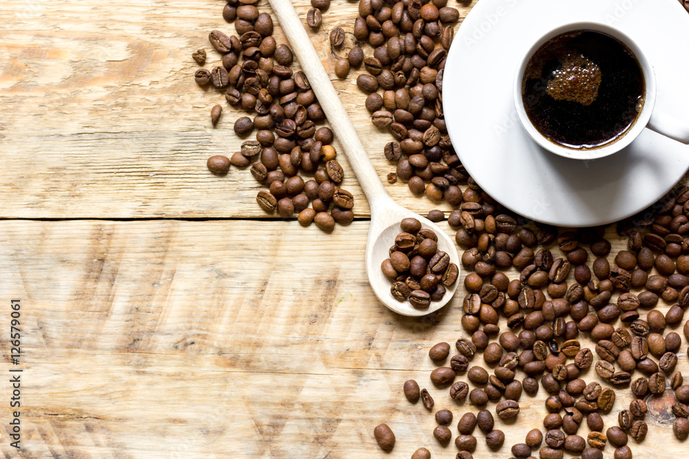 cup of coffee, beans and spoon on wooden background cup of coffee, beans and spoon on wooden background