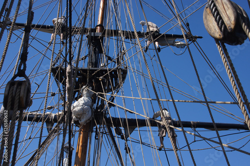 Crew unfurls a sail on a yardarm photo