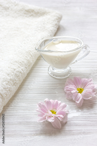 cream and spa on wooden background with flowers