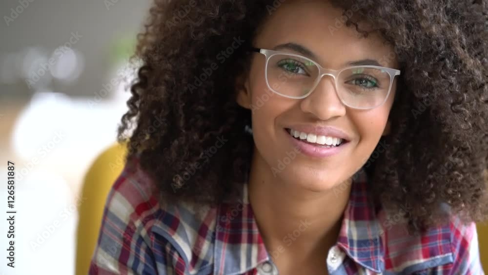 Mixed-race girl with eyeglasses reading book at home Mixed-race girl with eyeglasses reading book at home
