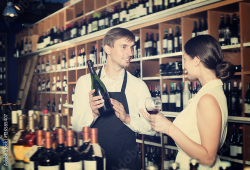 Positive seller man giving sample taste of wine