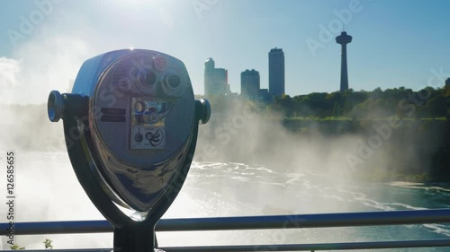 A coin operated binocular viewer located in Niagara Falls with a view to the falls out of focus in the background.