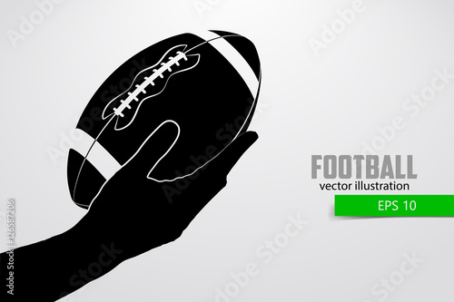 Hand holds the rugby ball, silhouette.