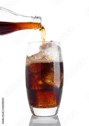 Pouring cola soda drink into the glass with ice