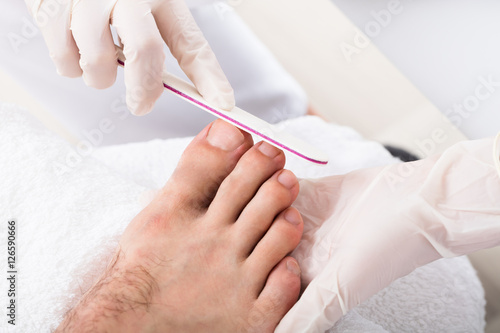 Beautician Hand Filling Person's Nail