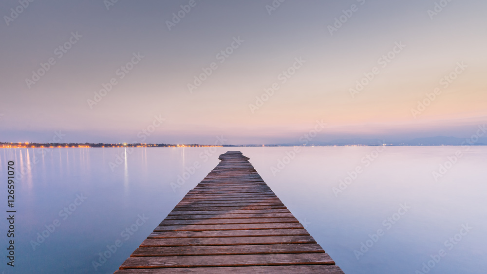 Fototapeta Długi Drewniany nabrzeże na Garda jeziorze przy zmierzchem