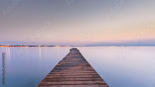 Long Wooden Wharf on Garda lake at sunset