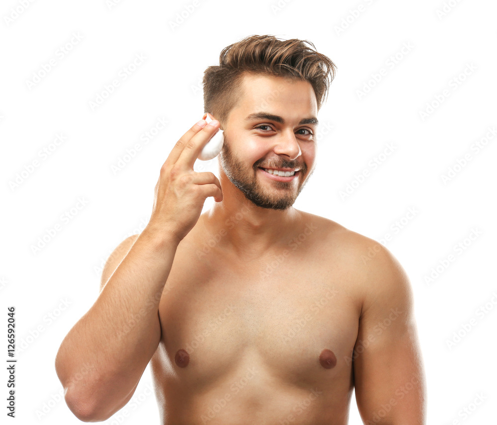Fototapeta premium Young man applying shaving foam isolated on white