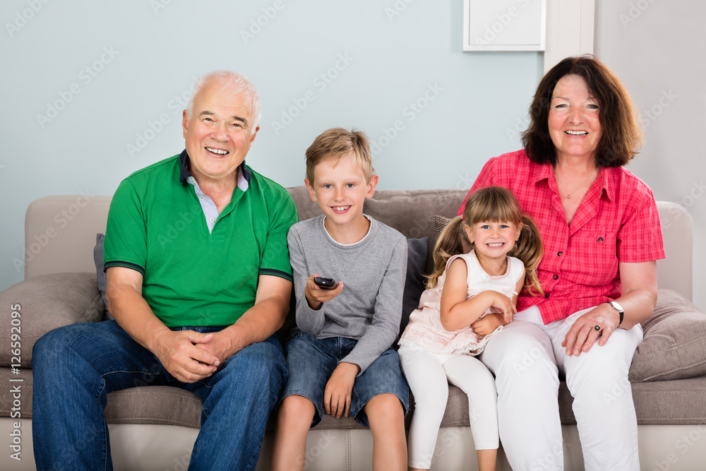 Grandparent And Grandchildren Watching Television Together