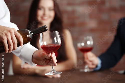 Male hands pouring red wine...