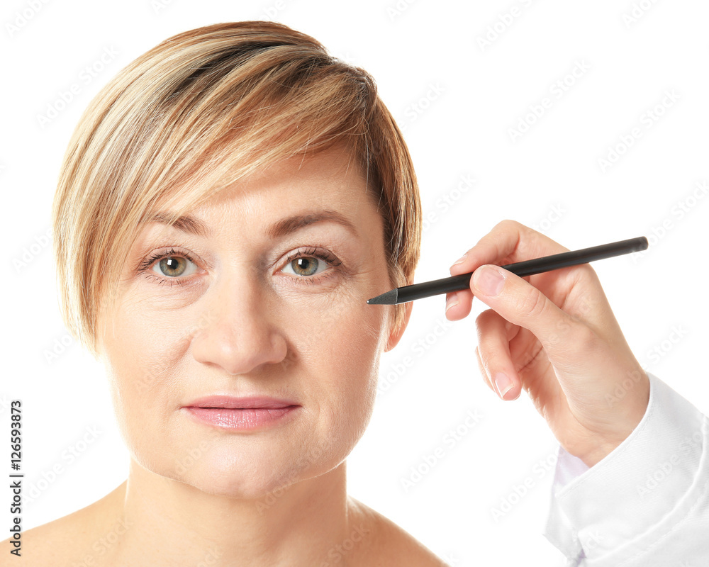 Surgeon hand drawing marks on female face for plastic operation Surgeon hand drawing marks on female face for plastic operation