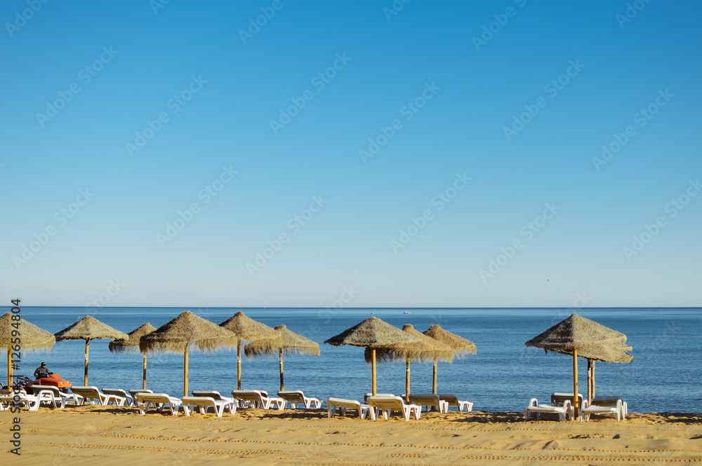 Beach umbrella chairs on the sunny blue sky beach outdoors background