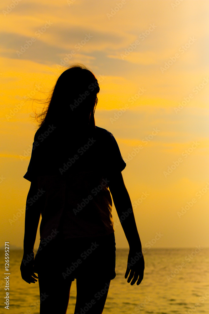 Silhouette of young woman standing at relax pose or freedom pose