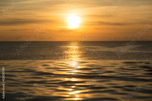 Infinity edge pool with sea underneath sunset © steheap