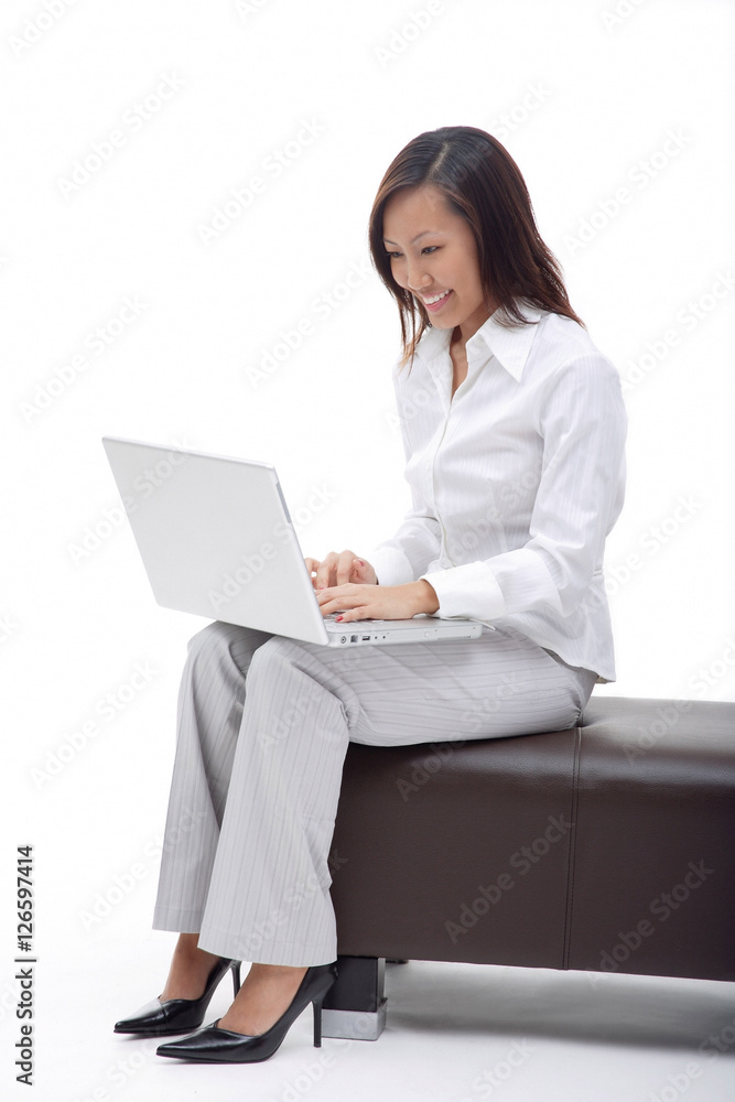 Business woman sitting on bench, using laptop Business woman sitting on bench, using laptop