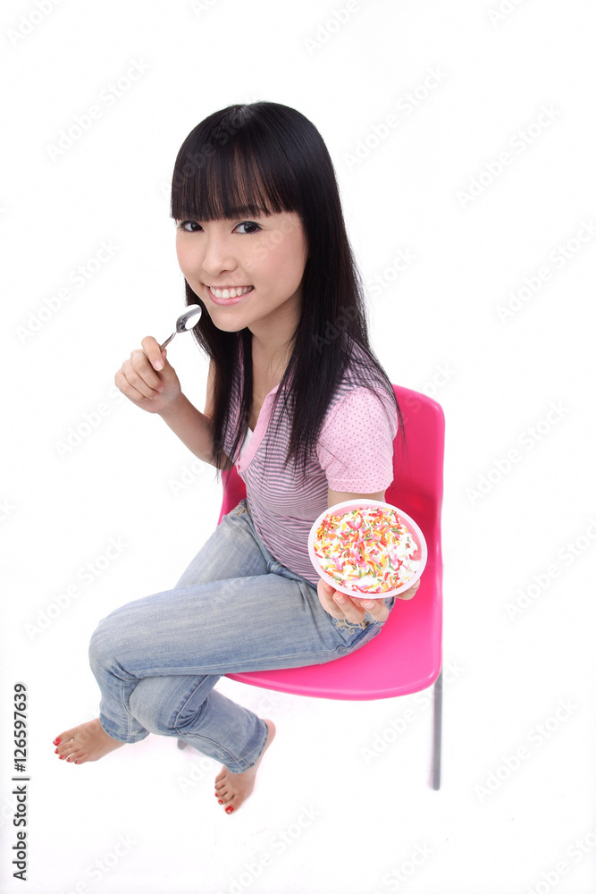 Young woman sitting, holding bowl of ice cream Young woman sitting, holding bowl of ice cream