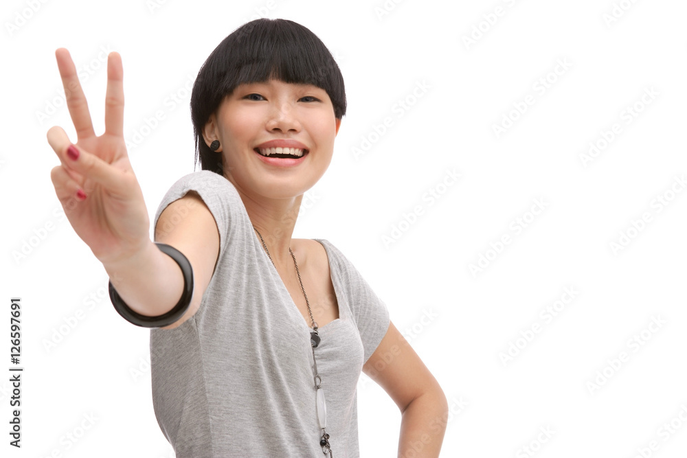 Young woman smiling at camera, making peace sign Young woman smiling at camera, making peace sign