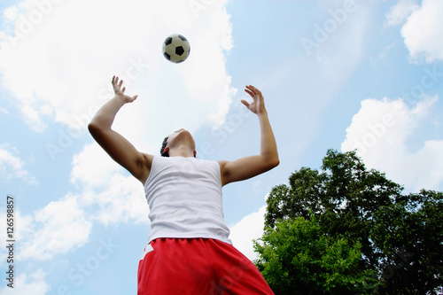 Man playing soccer, looking up at ball